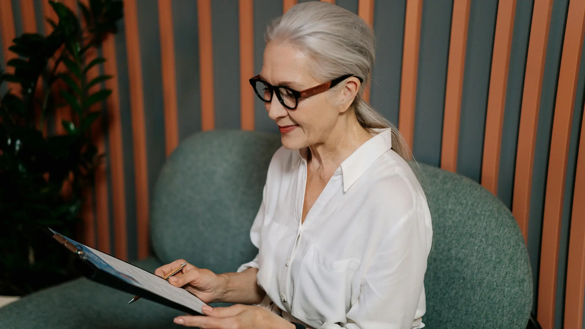 Woman with a clipboard in professional business attire hero